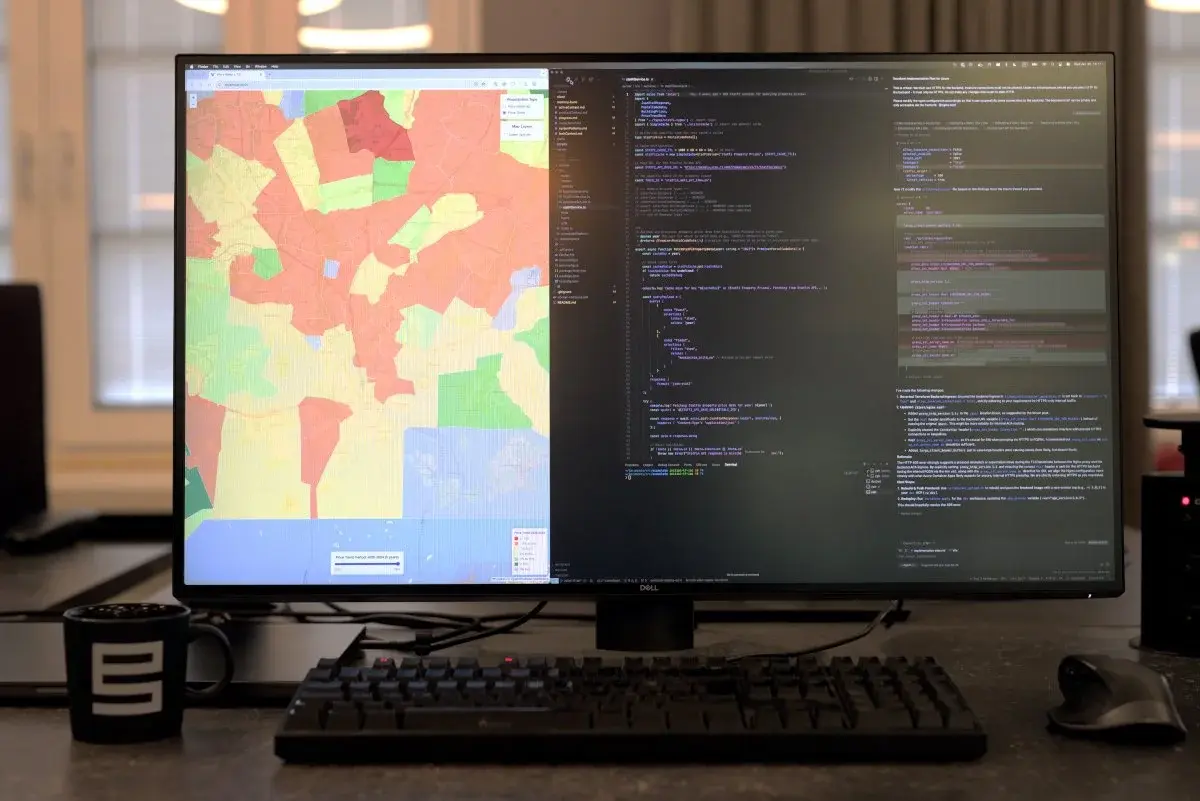 A desk workstation with screens in use during a vibe coding session